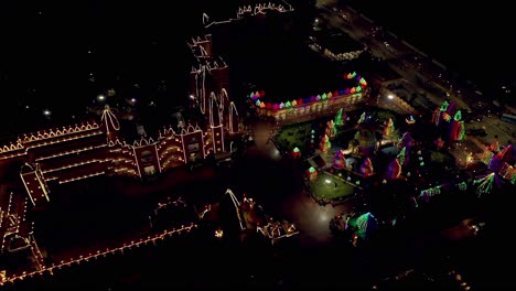 La-Cámara-De-Vista-Aérea-De-Drones-Va-Hacia-Atrás,-Donde-El-Gran-Templo-De-Cristal-Se-Ve-Muy-Hermoso-Y-Glorioso-Con-La-Iluminación-Y-Mucha-Gente-Entra-Y-Ve-La-Iluminación.