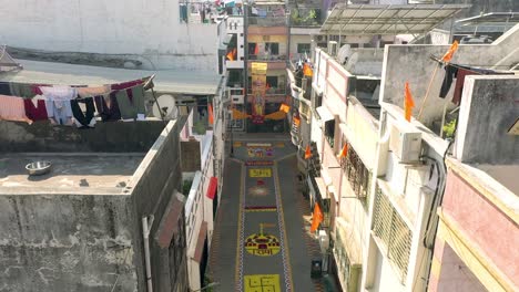 AERIAL-DRONE-VIEW-The-drone-camera-is-moving-forward-where-the-rangoli-of-Jai-Shri-Ram-is-visible-on-the-big-road-and-people-are-watching-both-the-rangoli-and-the-drone-from-above