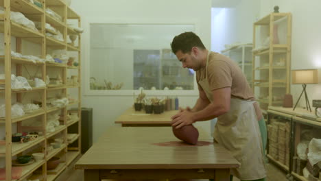 Artista-De-Alfarería-Preparando-Material-Para-Dar-Forma-A-Trozos-De-Arcilla-Marrón-Cruda-En-El-Taller