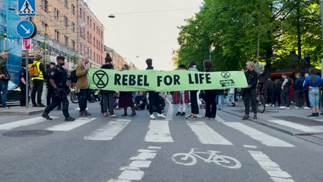 Slomo-of-police-officer-walking-in-front-of-banner-at-demonstration