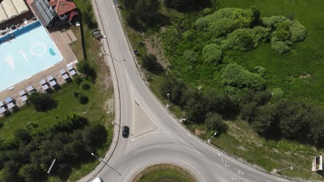 Vista-Aérea,-Montaña-Zlatibor-Serbia,-Tráfico-En-La-Rotonda-Que-Revela-Una-Zona-Turística-Con-Casas-Y-Hoteles-En-Un-Día-Soleado-De-Verano