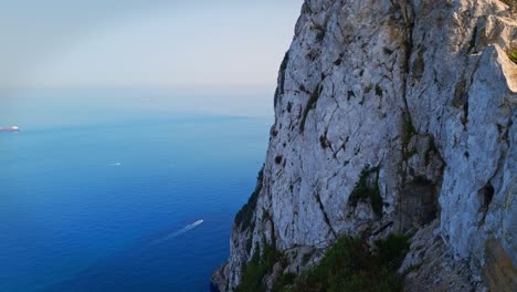 Statische-Aufnahme-Von-Booten,-Die-Auf-Dem-Meer-Segeln,-Mit-Einem-Hügel-Daneben