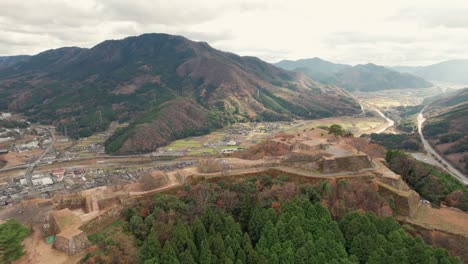Japanese-Mountain-Range-Valley-Aerial-Drone-Landscape-Drone-Flying-Above-Outskirts-of-Kyoto-in-Takeda-Castle-Ancient-ruins,-hyogo-asago