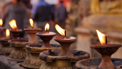 Close-view-of-butter-lamps-at-sunrise-at-the-Monkey-Temple,-Kathmandu,-Nepal