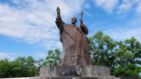 Scenic-landscape-view-of-bronze-statue-of-Pope-John-Paul-II-religious-landmark-against-blue-sky-in-the-capital-city-of-East-Timor,-Southeast-Asia