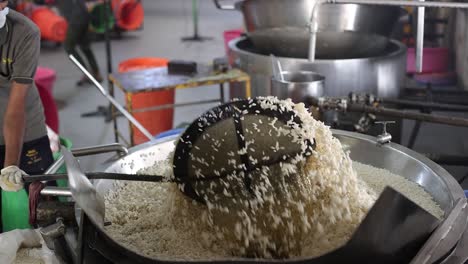 pov-shot-large-oil-frying-and-men-mixing-mixing-mamara-into-large-bowl-of-oil