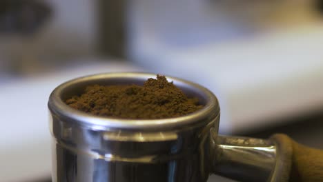 Guy-Weighting-Coffee-Powder-in-a-Filter-Handle-with-a-Spoon-at-Work-in-a-Coffee-Shop-in-France,-Day,-Close-Up