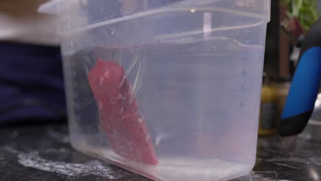 Vacuum-Sealed-Steak-Package-Form-The-Sous-Vide-Being-Placed-Into-Container-With-Water