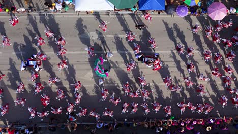 El-Dron-Desciende-Sobre-Trajes-De-Pájaros-Blancos-Y-Plateados-Rojos-Y-Sombras-De-La-Gran-Marcha-Del-Carnaval-En-Curazao.