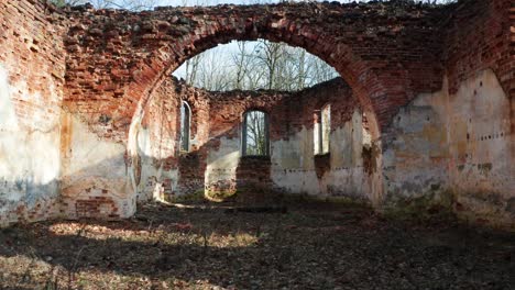 Walk-through-arch-shape-brick-wall,-abandoned-church-remains-without-roof