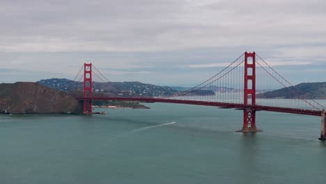 Telephoto-drone-shot-of-the-golden-gate-bridge-with-traffic-and-a-boat-underneath