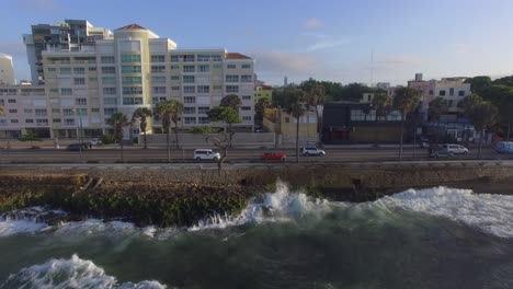 Luftaufnahme-Eines-Roten-Mustangs,-Der-An-Der-Küste-Des-Malecon-In-Der-Stadt-Santo-Domingo-Fährt