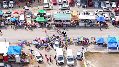 Drone-bird's-eye-view-above-vibrant-umbrellas-and-tent-shades-along-empty-street-for-Grand-March-parade-in-Carnaval