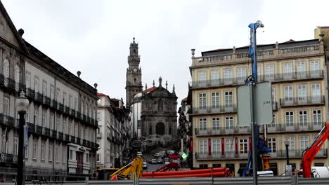 Static-shot-of-Igreja-dos-Clerigos-and-its-tower,-operational-machinery-in-foreground