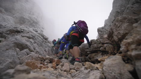 En-Medio-De-Una-Espesa-Niebla,-Unos-Excursionistas-Decididos-Caminan-Hacia-La-Cima-Del-Triglav.