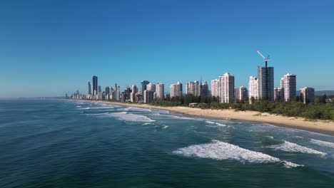 Forward-moving-rising-aerial-view-over-Main-Beach-looking-South-towards-Surfers-Paradise,-Gold-Coast,-Australia