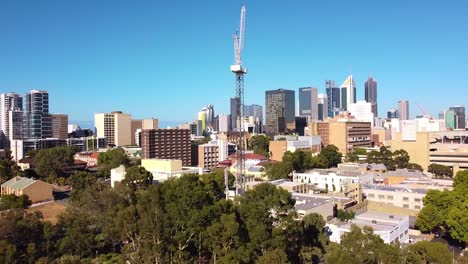 Dolly-Izquierda-Vista-Aérea-De-La-Grúa-De-Construcción-Con-Los-Edificios-De-La-Ciudad-De-Perth-En-El-Fondo