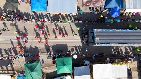 Top-down-bird's-eye-view-static-of-street-grand-march-carnaval-performers-and-dancing-shadows