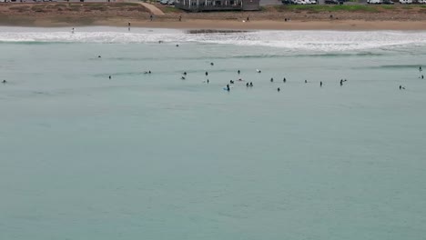 Drohnen-Luftaufnahme-Von-Surfern-Am-Strand-Und-Im-Meer-Mit-Wellen