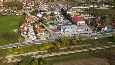 Aerial-View-of-Sevojno,-Small-Industrial-Town-in-Western-Serbia,-Green-Landscape-and-Buildings-on-Sunny-Autumn-Day,-Revealing-Tilt-Up-Drone-Shot