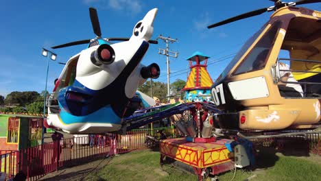 Children-onboard-helicopter-ride-attraction-in-theme-park,-handheld