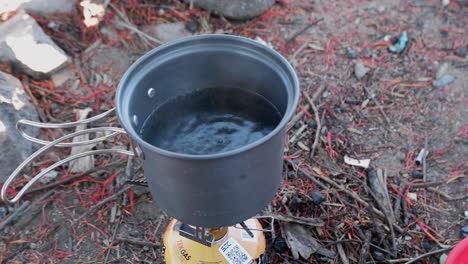 Kleiner-Topf-Auf-Dem-Camping-Gasherd-Wird-Aufgeheizt-Und-Steht-Beim-Camping-Kurz-Vor-Dem-Kochen