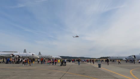 Ein-Hubschrauber-Fliegt-über-Menschen,-Um-Bei-Einer-öffentlichen-Flugshow-Seine-Fähigkeiten-Zu-Demonstrieren