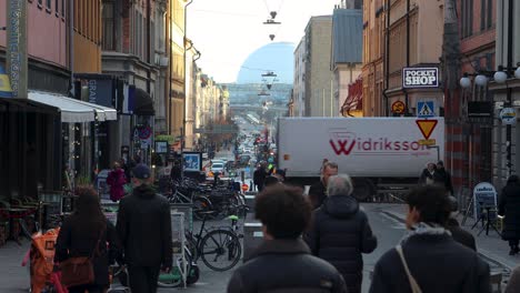 Truck-crosses-busy-pedestrian-street-in-Stockholm,-centered-static