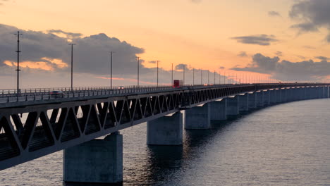 Vibrant-sunset-sky-with-traffic-moving-over-iconic-Oresund-bridge