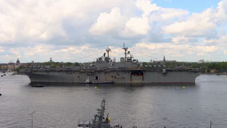 Battleship-USS-Kearsarge-and-smaller-boats-on-cloudy-day-in-Stockholm