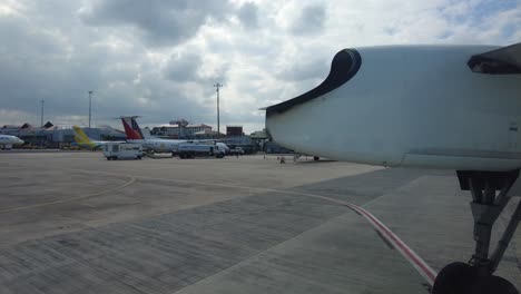 Punto-De-Vista-De-Un-Pasajero-De-Avión-En-El-Lado-De-La-Ventana-Cerca-Del-Ala-Con-El-Tren-De-Aterrizaje-Moviéndose-Para-Estacionar,-Cámara-En-Mano