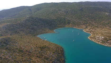 Aerial:-Slow-panning-drone-shot-of-planitis-bay-of-the-island-of-Kira-Panagia-in-Sporades,-Greece-during-sunset