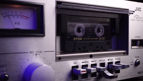 TDK-Audio-Cassette-Tape-Playing-in-Vintage-JVC-Deck-Player-With-VU-Meters,-Close-Up