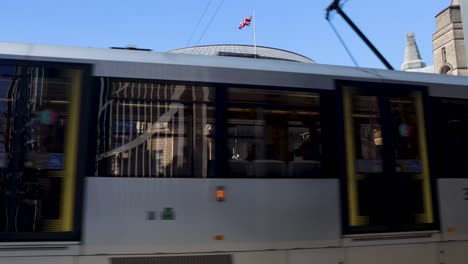 Straßenbahn-Fährt-An-Der-Manchester-Central-Library-Vorbei,-Mit-Der-Britischen-Flagge-Oben-Drauf,-Statisch