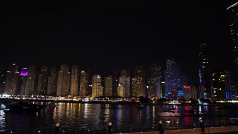 Panorama-Del-Horizonte-Del-Paisaje-Urbano-Frente-Al-Mar-De-Dubai-Por-La-Noche,-Luces-Y-Rascacielos