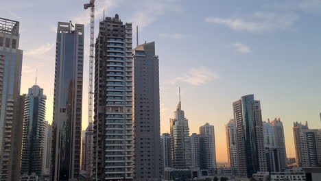 Rascacielos-Y-Torres-Alrededor-De-Dubai-Marina-Uae,-Tráfico-Por-Carretera-Con-Cielo-Al-Atardecer-En-El-Fondo-60fps