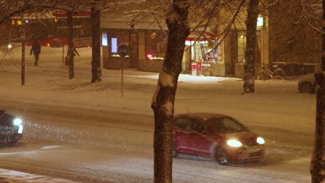 Traffic-and-pedestrians-on-snowy-street-at-night