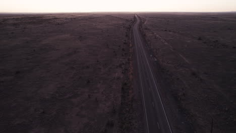 Eine-Abgelegene-Wüstenautobahn-Ohne-Autos-Bei-Sonnenuntergang,-Luftdrohne