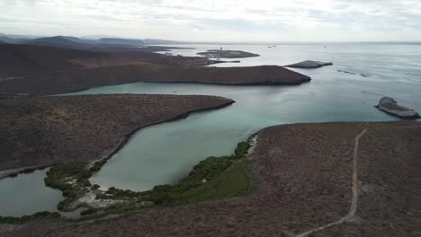 Baja-california's-playa-balandra,-showcasing-serene-waters-and-rugged-landscape-at-dusk,-aerial-view