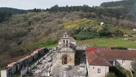 Drone-descends-to-Santa-Maria-de-Punxin-in-Ourense-Galicia-Spain-front-entrance-doors-and-cemetery-grounds