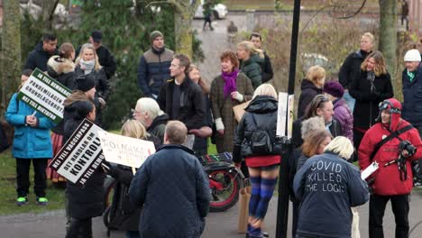 Menschen-Mit-Schildern-Stehen-Und-Parken-Bei-Einer-Protestkundgebung-Zur-Covid-Verordnung