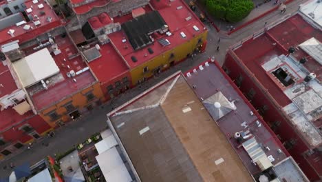 Daytime-view-over-residential-area-in-San-Miguel-de-Allende-and-Parroquia-de-San-Miguel-Arcángel,-top-down-tilt-up