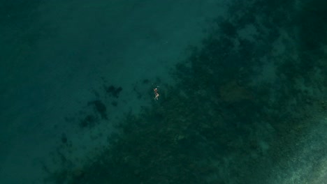 Overhead-shot-of-girl-swimming-alone-on-beautiful-sea-in-the-Mediterranean-sea