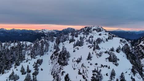 Malerische-Schneebedeckte-Berg--Und-Baumlandschaft,-Farbenfroher-Sonnenuntergangshimmel