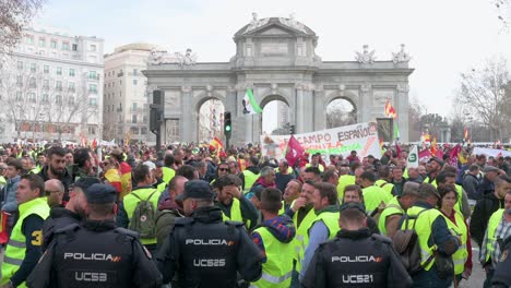 Police-officers-stand-guard-as-Spanish-farmers-and-agricultural-unions-gather-at-Plaza-de-la-Independencia-to-protest-against-unfair-competition,-agricultural-and-government-policies