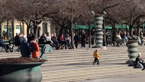 Un-Niño-Corre-Delante-De-Sus-Padres-En-Un-Parque-Soleado-En-Estocolmo,-Suecia