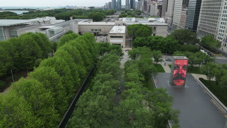 Chicago-USA,-Aerial-View-of-Millennium-Park-and-Buildings-on-Michigan-Avenue,-Revealing-Tilt-Up-Establishing-Drone-Shot