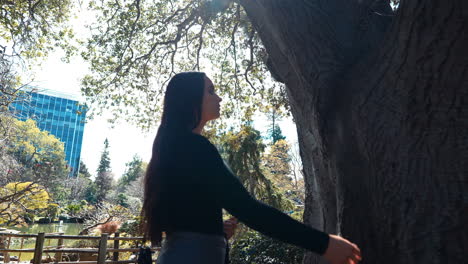 a-4k-slow-motion,-stabilized-video-depicting-a-beautiful-young-middle-eastern-female-model-exploring-a-lush-Japanese-Tea-Garden-slowly-moving-to-touch-a-tree,-peninsula,-california