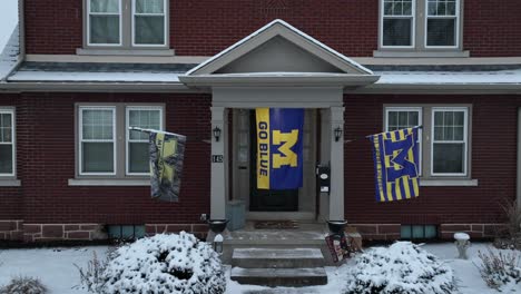Banderas-De-La-Universidad-De-Michigan-Frente-A-Una-Casa-En-Una-Zona-Residencial-Americana