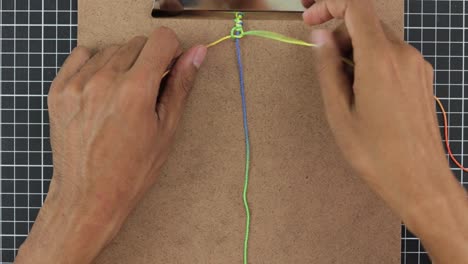 Timelapse-of-hands-crafting-colorful-rainbow-macrame-bracelet,-vibrant-threads